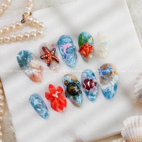 blue press on nails from the LuxeClaw Ocean Nails collection with coral starfish turtle and aqua wave details